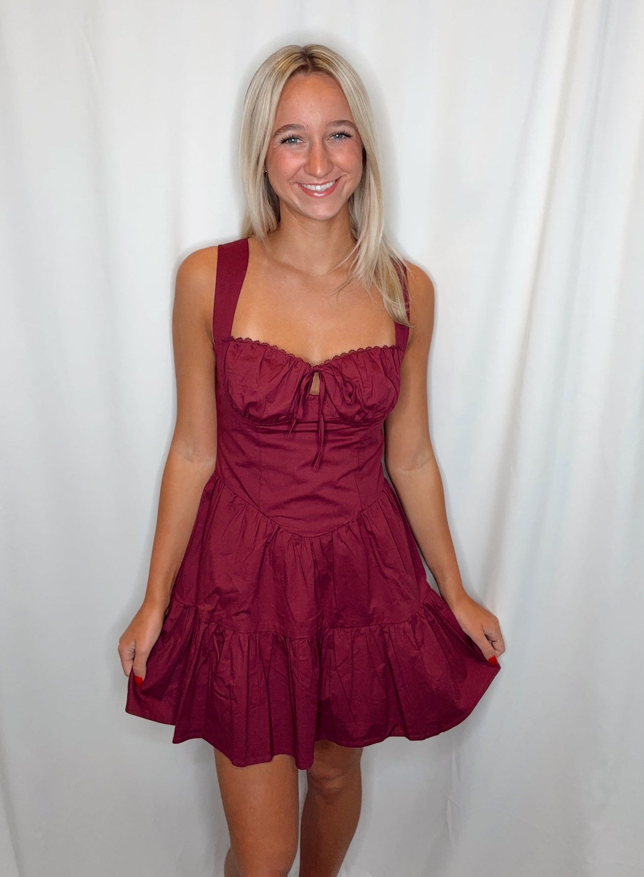 Woman wearing a burgundy dress against a white background